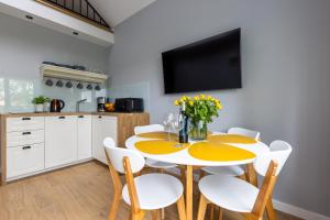 a kitchen and dining room with a yellow table and chairs at Apartamenty na wydmach in Łeba