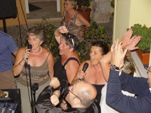 a group of women singing in front of microphones at B&B Corte Barbieri in Dolcè