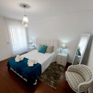 a bedroom with a large bed and a chair at Casa De Luxo em Esposende in Esposende
