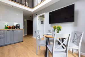 a kitchen and dining room with a table and chairs at Apartamenty na wydmach in Łeba