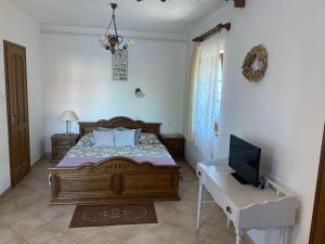 a bedroom with a bed and a desk with a television at Levendula Apartman Zalakaros in Zalakaros