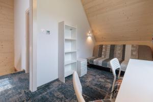 a bedroom with a bed and a desk in a room at Stachelisko - domki i pokoje in Chochołów