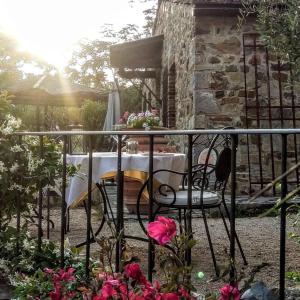 un tavolo con sedie su un balcone fiorito di Podere Palazzolo (ADULTS ONLY) a Castellina in Chianti