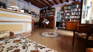 una sala de estar con estanterías y una habitación con cama en Albergo Giulia Gonzaga, en Sabbioneta