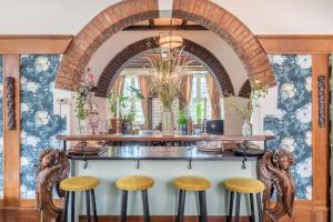 a bar with wooden stools in front of a wall at Hotel Nieuw Antiek in Helden