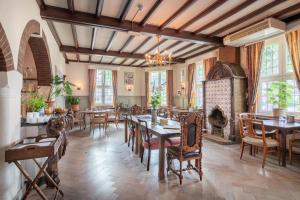 a dining room with tables and chairs and a fireplace at Hotel Nieuw Antiek in Helden