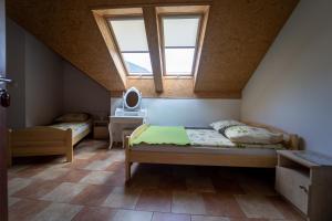 a attic bedroom with two beds and a window at Pokoje Gościnne Martynka in Białogóra