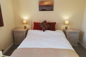ein Schlafzimmer mit einem weißen Bett und zwei Nachttischen in der Unterkunft Lane Foot Family accommodation Winter Deals Nov to March on 3 nts or more in Ambleside