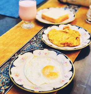 a table with plates of food and a drink at Hotel White Pearl in Lahore