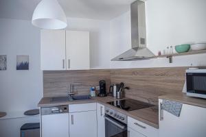 a white kitchen with a sink and a stove at Suite Cuveé Zell in Zell an der Mosel