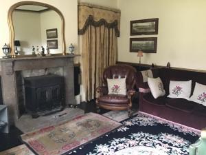 a living room with a couch and a fireplace at Bank Top Farm B&B Hartington in Buxton