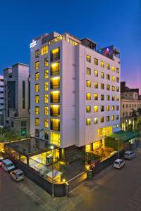 a large white building with a parking lot in front of it at Country Inn Panjim Goa in Panaji