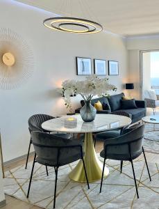 ein Wohnzimmer mit einem Tisch mit Stühlen und einem Sofa in der Unterkunft MyBlueVista LUXURY PANORAMIC SEA VIEW APARTMENTS CAP D AIL NEAR MONACO in Cap d'Ail