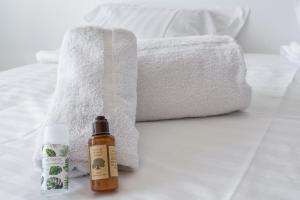 a bottle of essential oil and towels on a bed at Studio du Grand Sud - Welkeys in Nice