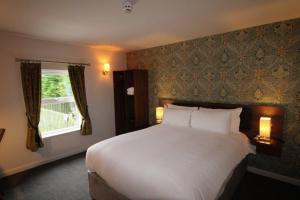 Un dormitorio con una gran cama blanca y una ventana en rooms @ the dolau inn en New Quay
