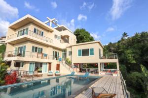 a large house with a swimming pool in front of it at The Boathouse Villa in Salad Beach
