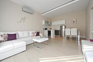 a living room with a white couch and a table at Apartments Villa Violet in Zadar