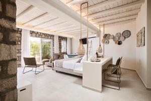 a bedroom with a bed and a table and chairs at Nirome Luxury Suites in Adamantas