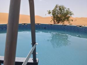 a swimming pool in the middle of the desert at Sahara Majestic Luxury Camp in Merzouga