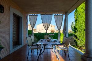 a patio with a table and chairs on a porch at La Casa de las Flores Casa Rural in Pulgar