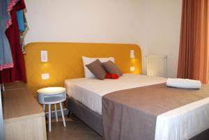 a bedroom with two beds and a yellow headboard at Taormina Suite Bardolino in Bardolino