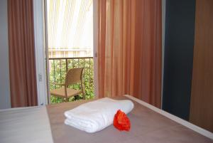 un letto con balcone e una pila di asciugamani. di Taormina Suite Bardolino a Bardolino