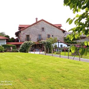 a large stone house with a lawn in front of it at Casona Camino de Hoz in Anero