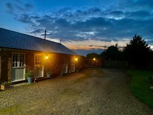 een bakstenen huis met lichten aan de zijkant bij Relaxing Retreat Around Nature in Wrexham