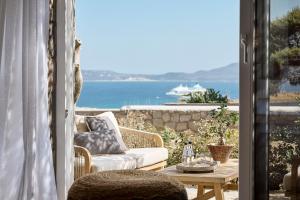 a patio with a couch and a table with a view of the ocean at Nirome Luxury Suites in Adamantas