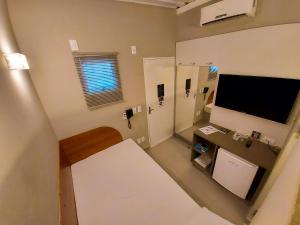 a small room with a flat screen tv on the wall at Oasis Motel in Piracicaba