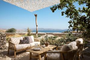 a patio with a couch and a table and chairs at Nirome Luxury Suites in Adamantas