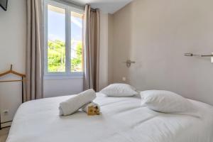 ein weißes Bett mit einem Teddybären drauf in der Unterkunft Superb bright flat with balcony and sea view in Cassis - Welkeys in Cassis