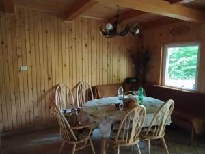 a dining room with a table and chairs at Podklanci-house in the forest in Knežak