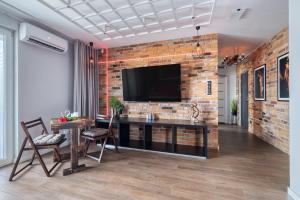 a living room with a television on a brick wall at Relaxroom in Reda