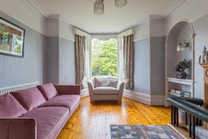 uma sala de estar com um sofá roxo e uma cadeira em Glenholmekendal em Kendal