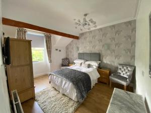1 dormitorio con 1 cama y 1 silla en Glenholmekendal, en Kendal