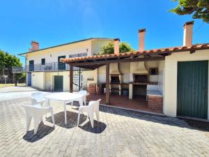 a patio with a table and chairs in front of a house at Quinta Manuel Santo in Nazar&eacute;