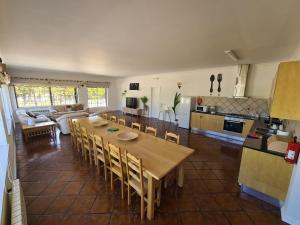 cocina y sala de estar con mesa de madera y sillas en Quinta Manuel Santo, en Nazaré