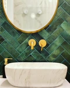 a bathroom with a white sink and a mirror at Apartament Tsuru in Dziwnówek