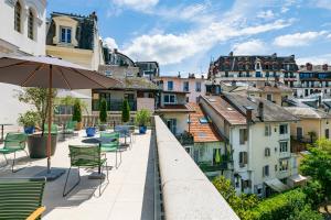 widok na miasto z krzesłami i parasolem w obiekcie Belle Epoque w Aix-les-Bains
