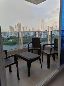 balcón con sillas y mesas y vistas a la ciudad en Ocean blue Ed Conquistador, en Cartagena de Indias