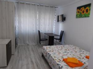 Peninsula-Cazino,Dalvi في كونستانتا: غرفة نوم بسرير وطاولة مع كراسي