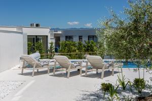 a patio with chairs and a table and a pool at Villa Bianca in Vantačići