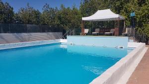 a swimming pool with a gazebo next to at Cortijo San José in Seville