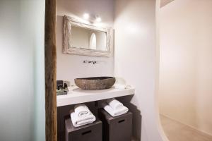a bathroom with a sink and a mirror at Nirome Luxury Suites in Adamantas