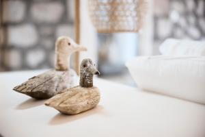 two wooden ducks sitting on a table at Nirome Luxury Suites in Adamantas