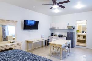 uma cozinha com armários brancos e mesas e uma televisão em La Casa de Pino em Oaxaca de Juárez