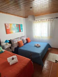 1 dormitorio con 2 camas y ventana en Casa da Costa en Madalena