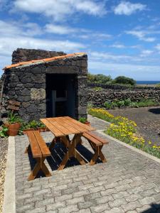 - une table de pique-nique en bois devant un bâtiment en pierre dans l'établissement Casa da Costa, à Madalena 13 autres photos