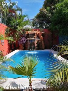 a swimming pool in a yard with a fountain at Casa 7 in Mazatlán